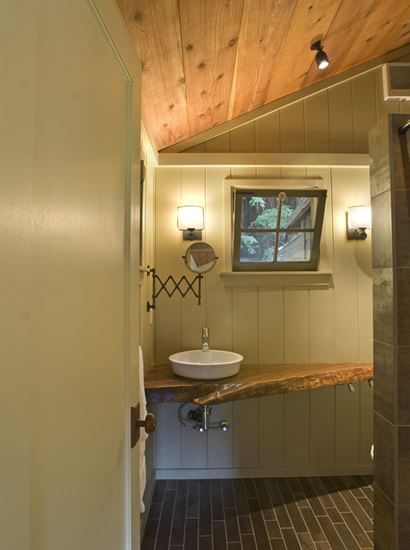 Bathroom with large two-person walk-in shower, heated floors, natural wood vanity and polished chrome fixtures.