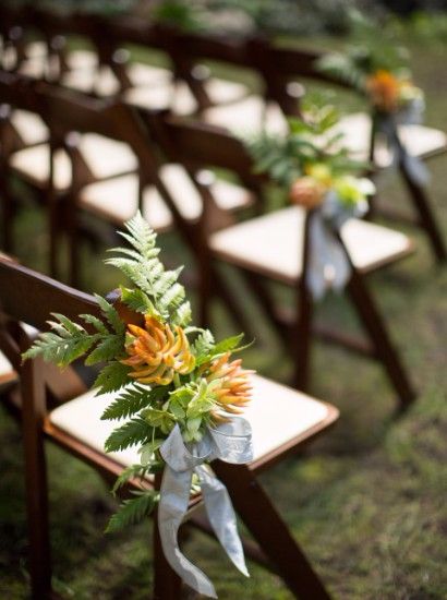 Chairs set with yellow floral arrangement for wedding.