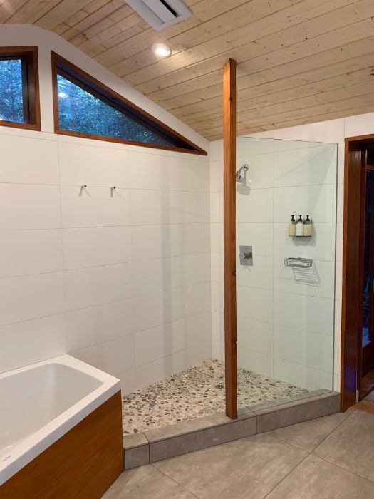 Walk-in shower next to oversized tub with heated tile floors.