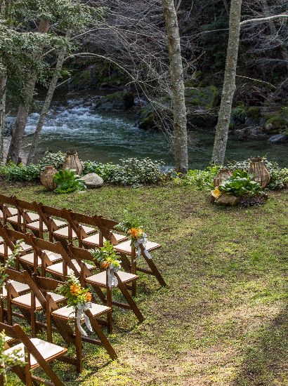 Chairs set with river in view and adorned with yellow floral arrangement for wedding/